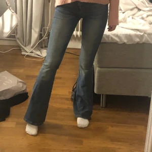 Bootcut jeans från zara - Blåa bootcut jeans från zara. Använda en del och därför slitningarna längst ner på benen baktil💕. Mitt pris är 175kr och i stl 34💞 köparen står för frakten!!💕 
