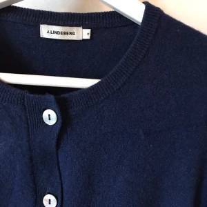 J.Lindeberg kofta, M, kashmir & merino  - Mörkblå kofta från J.Lindeberg! Strl M Blå cardigan med knappar 70% merinoull 30% cashmere  Fint använt skick. Otroligt mjuk, varm och skön!  Kan mötas i Stockholm eller skickas mot fraktkostnad! ✨🌸✨