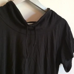  - Snygg t-shirt med typ turtleneck som har snörning.