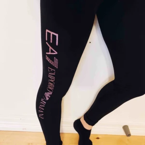  - Träningstights från Armani. Aldrig använda, höga i midjan och material som sätter sig efter personlig passform. Mycket sköna svarta tights med tryck av Armani på två ställen i lila-skimmrig färg. Fler bilder kan skickas, frakt tillkommer. 