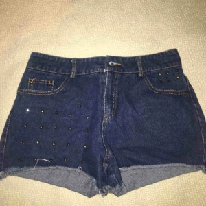  - Denim shorts med guld metall detaljer på. Storleken står inte på shortsen men skulle kunna tror det är storlek S. Knapparna är lite trasiga men det kan lagas. Priset kan diskuteras :)