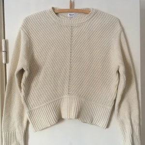  - Stickad tröja från Filippa K i bomull. Ganska kort modell i strl M, men kan passa strl S-L beroende på hur du vill att den ska sitta.   Benvit i färgen.  Frakt inkluderat i priset.