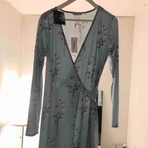  - Oanvänd blommig klänning från NELLY.COM. Nypris var över 199kr men säljes nu för 50kr. Storlek M. Köparen står för frakt om det ej finns möjlighet att mötas upp. :)