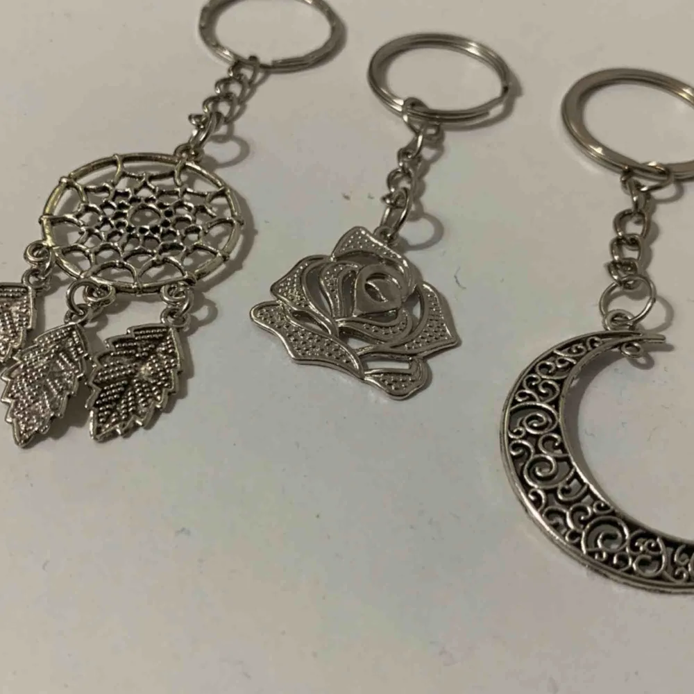 Coola nyckelringar. En i form av en drömfångare en av en ros och en av en måne. Alla i silverfärgad metall och bea kvalite. . Accessoarer.