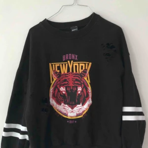  - Svart collegetröja med revor i. Bra skick. 