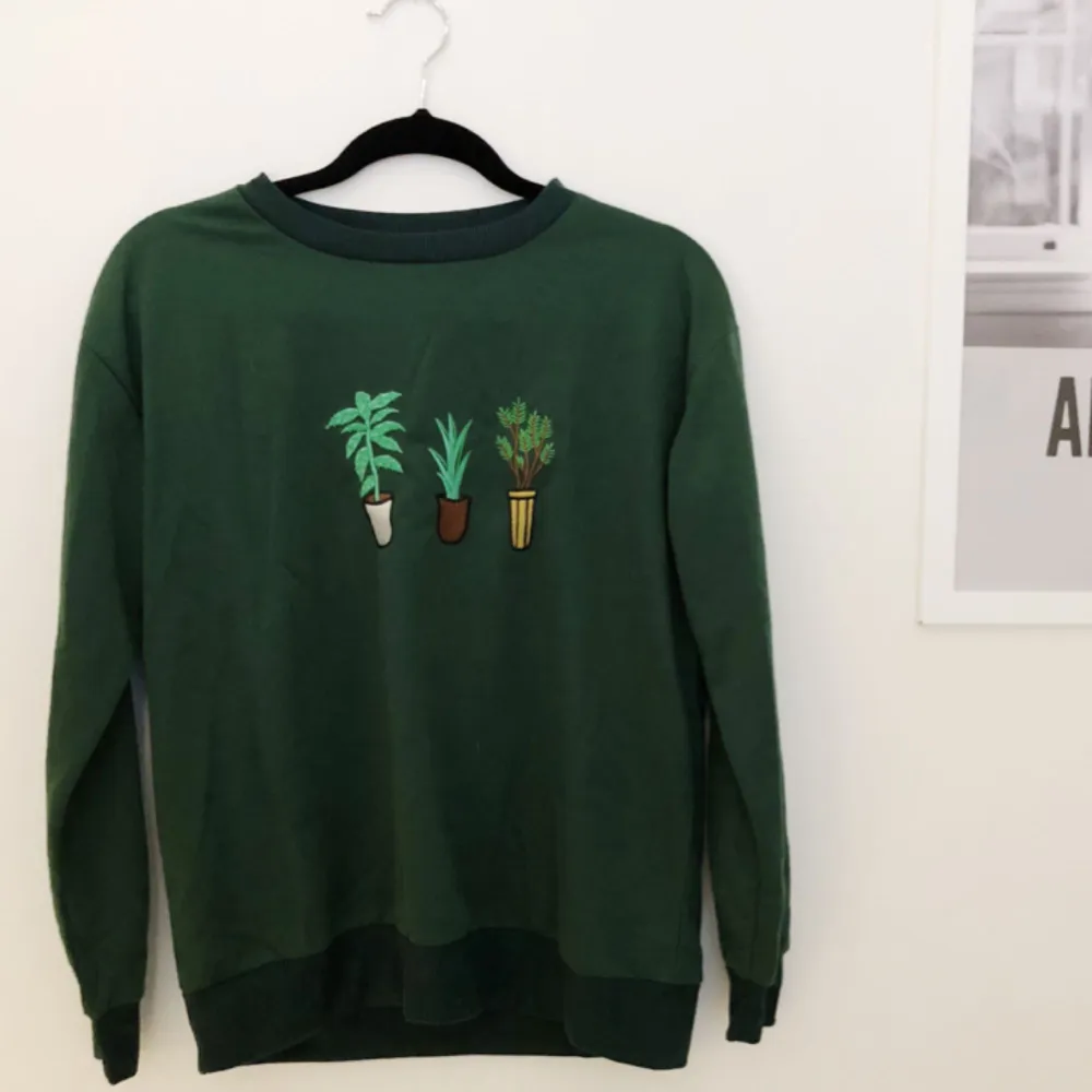 Grön sweatshirt med växter på. Köpt på second hand så både märket och storleken är oklart men passar S/M. Hoodies.