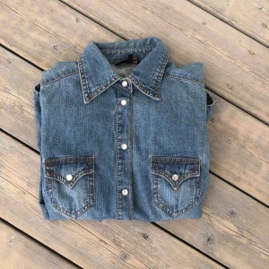  - Jeans skjorta som aldrig är använd. Vita stenar som knappar (den är lätt att knäppa).