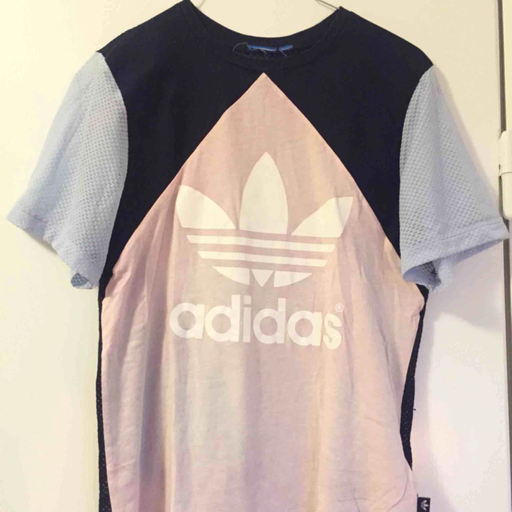 T-shirt från Adidas. Ljusblå, rosa, vit och mörkblå och genomskinlig backsida (se bild 3). Delar på frakten. . T-shirts.