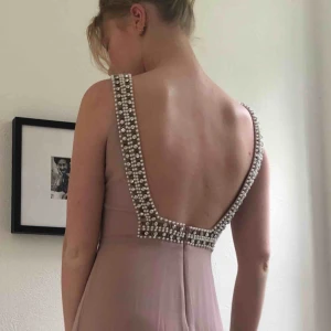  - Smuts rosa klänning från asos använd 1 gång köpt för 2 år sedan. Fina pärlor och kristaller i den djupa ryggens kanter. Klänningen har ett kortare släp som är tunt och lätt. Vet inte storlek den passar för dig som är s-m väldigt bra 