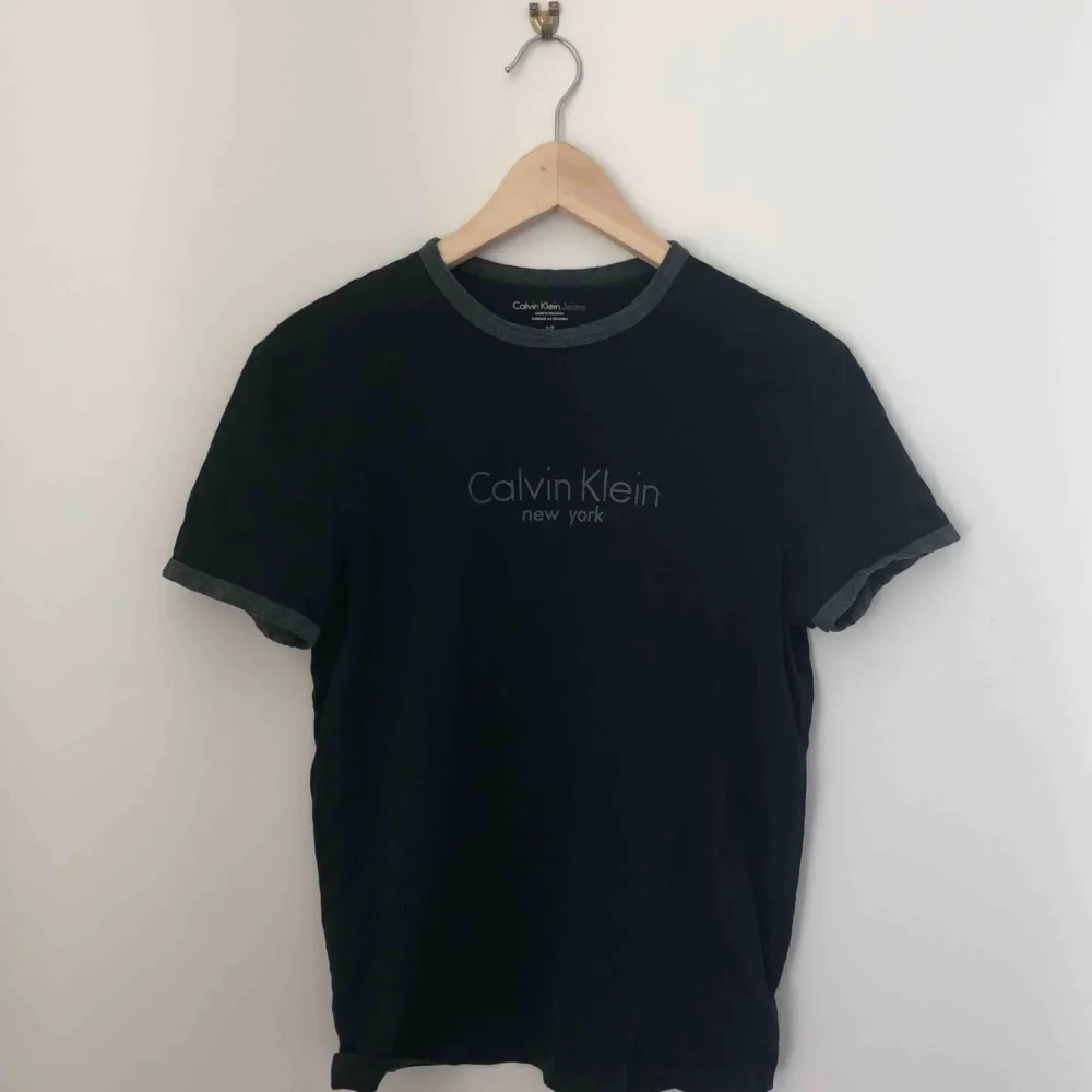 svart t shirt med gråa detaljer från calvin klein kan mötas längst roslagsbanan och i stockholm, annars står köparen för frakt.. T-shirts.