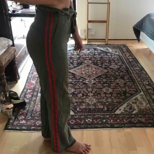  - Gröna vida byxor men fina detaljer i midjan och röda streck längs benet! Frakt står köparen för<3