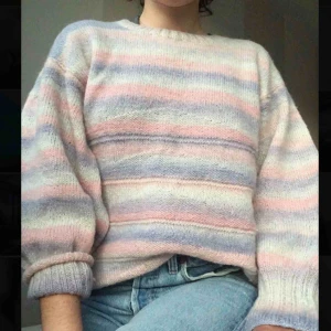  - Stickad tröja i olika nyanser av rosa/lila. Har två små hål på baksidan (syns knappt -se bild)