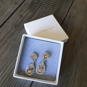  - Lily and Rose örhängen. Aldrig använda. Ljusrosa stenar i mitten. 