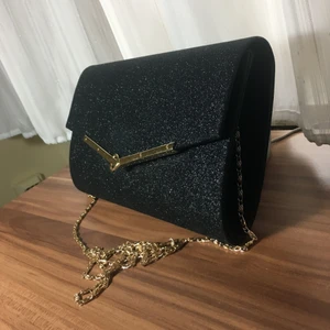  - Helt ny oanvänd väska köpt en vecka sen. Tänkte ha den på bröllop men hitta en som passade bättre. Väskan är glittrig och svart med guld kedja som kan tas bort. Ny pris: 400kr. Tveka inte om du har några frågor 💗🖤💗