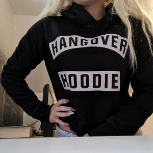  - Svart croppad hoodie från Madlady med texten "Hangover hoodie" Mycket bra skick. Pris kan diskuteras 😊