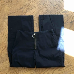  - Marinblå högmidjade byxor i kostymbyxmaterial med kortare längd och utsvängda. Skickar gärna bild efter förfrågan!