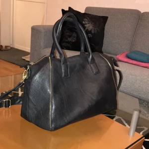  - Större väska från Accent men en stor dragkedja med 3 mindre fack i och en mindre dragkedja på baksidan. Får plats med en 13 tums Macbook. Använd men i bra skick