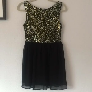  - Svart festklänning med guldiga detaljer från Elise Ryan.
Använd fåtal gånger, perfekt till nyår!