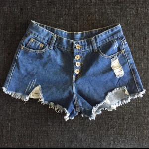  - Highwaistade jeansshorts med distress Fint skick, använda men inget slitage Kan postas men frakt tillkommer Kan mötas upp i Helsingborg/Klippan
