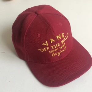  - Vans-keps i mörkröd färg med gul text, justerbar storlek 