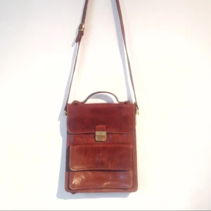  - Messengerbag i äkta läder från Italienska The Bridge. Fint skick förutom missfärgning från metallen vid ett spänne, men syns knappt. Annars superfräsch.