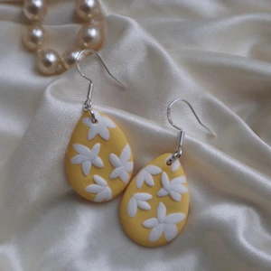 Gula dropp örhängen med vita blommor - Handgjorda örhängen i polymer lera!🤩 Krokar i 925 sterling silver! Droppen är 2,5cm!💗