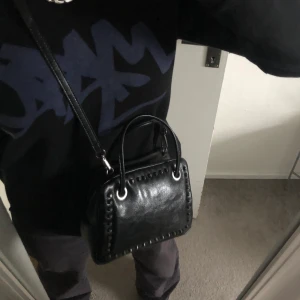 Cool väska från Zara - Säljer en helt oanvänd väska från zara! Jag har en liknade så säljer av den anledningen. Den är as cool och har så snygga detaljer. Axelbandet kan man reglera eller ta av. Köp direkt för 320kr!
