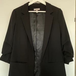 Svart kavaj med 3/4 ärm - En kavaj från hm med uppsydda ärmar. Skutsnygg som piffar upp en outfit med den lilla detaljen i ärmar. Fickor på båda sidor framtill! Stl 38 men passar även 36, inkl frakt!💕