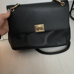 Svart väska  - Köpt på zalando. Snygg, stilren, rymlig väska från zalando. Kanppt använd så lika som ny! Den har långa band ich får plats med mycket.