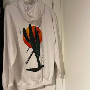 Vit hoodie med snyggt tryck  - Använd fåtal gånger, snyggt tryck på ryggen och fram. Frakt tillkommer. 