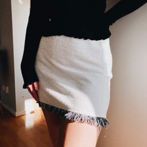 En vit kjol med svarta och vita fransar nertill från Zara. Använd ett fåtal gånger och i väldigt fint skick! Modellen bär vanligtvis storlek XS och materialet är inte genomskinligt och modellen är liknande en tubkjol, resor i midjan. Frakt ingår
