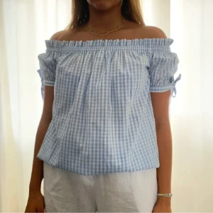 Rutig topp - Rutig offshoulder blus med rosetter vid ärmarna. Den är i storlek 34 men resåren upptill gör den stretchig så passar XS-S💙
