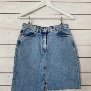 Ljus jeanskjol, Monki - Kjol som knäpps i fram med dragkedja och knapp. Använd men i fint skick. Passar mig som vanligtvis har storlek S men kan vara svår att få över höfterna om man har lite bredare höfter. Frakt tillkommer (59kr). 