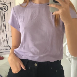 Lila tröja - Jag säljer min super söta lila t-shirt från weekday! Den är i ett tunt ribbat material och är super skön🥰 Frakt: 42
