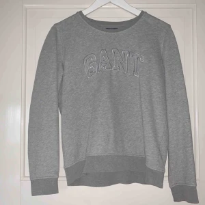  - Grå sweatshirt från GANT som är väldigt skön men sällan använd. Stort tryck på framsidan, inga överisa detaljer. Fler bilder kan skickas, frakt ingår ej.