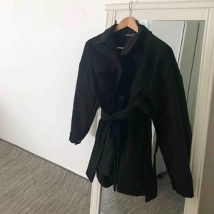  - Helt ny! En svart jacka med bälte från boohoo i storlek M. Bra skikt, dock är den för stor på mig. Skulle även passa som storlek L, annars är den rätt oversize för dess storlek. Kontakta för fler bilder och frågor. Frakt förekommer.