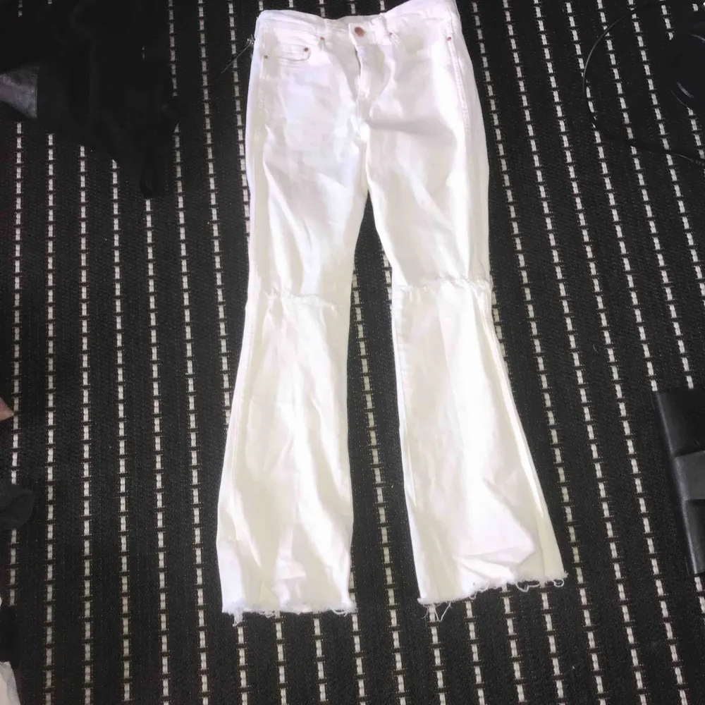 jätte fina vita bootcut jeans med slits vid knäskålen den är i jätte bra skick används bara 2 gånger den passar 150-155cm. frakt ingår ej. Jeans & Byxor.