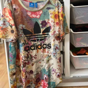  - Fin blommig adidas t-shirt i storlek S. Lite större/längre i modellen som ger en lite mer street stil. Köpt för 299kr säljer för 70kr + frakt. 
