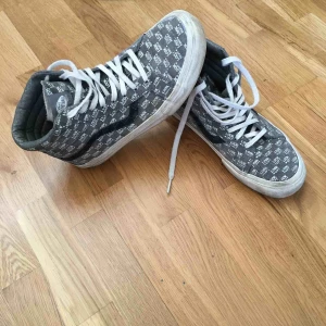 Sneakersnstuff x VANS ”Look Left” Sk8-High - Sneakersnstuff x VANS ”Look Left” Sk8-High i färgen gargoyle grey. Storlek 38. I gott skick, smått smutsig på sulan men går säkerligen att tvätta bort! Slitage på insida häl, inget som syns.   Orginallåda och 2 par skosnören i grått och rött medföljer. 