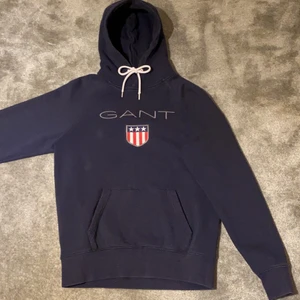 Gant hoodie - Säljer nu min gant hoodie då det inte är min stil något mer. Fin hoodie i bra skick, utan hål och fläckar. Köpt på pondus på killavdelningen och kan därav vara lite stor. Har inte kvittot kvar.                Pris kan diskuteras. 