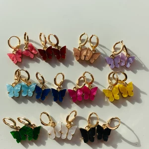 Fjäril örhänge - Alla skimrar även om det inte syns på bilden. Trendiga och söta. Rad 1: korall, röd, beige, lila. Rad 2: ljusblå, marinblå, rosa, gul Rad 3: grön, vit, svart. Alla örhängen kostar 60kr st och frakten blir 11kr oavsett hur många man vill köpa. De kommer från berlinz_shop vilket är en sida på Instagram❤️