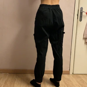 Svarta kargobyxor - Fina mjuka svarta kargobyxor. Säljer för att jag inte använder längre. Köpta från pull&bear för 400 säljer för 200. Man måste ha bälte för att knapparna är sönder så pris kan diskuteras. Frakt ingår.
