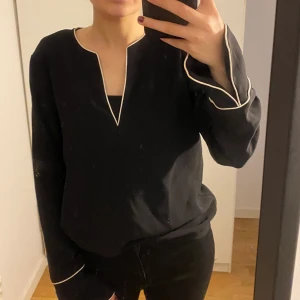 Svart skjorta - Svart skjorta med vita detaljer. Den är i storlek S men lite tight