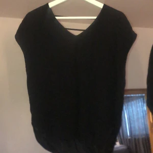 Svart t-shirt - En svart vringad t-shitt med detalj i ryggen