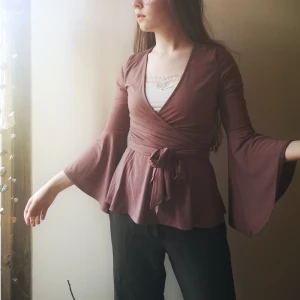 Gammelrosa omlottblus - Gammelrosa blus med omlott v-ringning, vida ärmar och band som går att knyta lite hur man vill 💝🌷 Den är i stretchigt material. Knappt använd! Frakt tillkommer. 