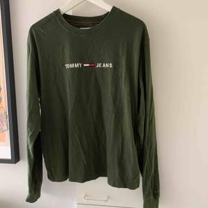 Grön tröja från Tommy Jeans köpt på Urban outfitters. Stor i storleken och sparsamt använd.