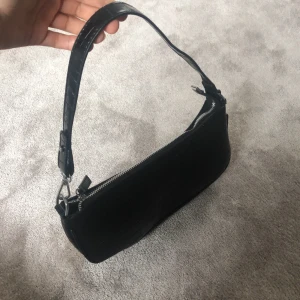 Svart liten axelväska  - Säljer denna svart lilla väska från ”By Anastasia”. Aldrig använd. Den är helt nytt skick!