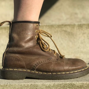 Dr Martens  - Bruna Dr Martens. Köpta i London 2010 och har vart med på dem flesta festivaler i landet så mycket väll använda. I och med att dom är i skinn så har dom nog ändå mer att ge. Ser inte storleken längre men är 90% säker på att dom är 38or. Frakten ingår:)