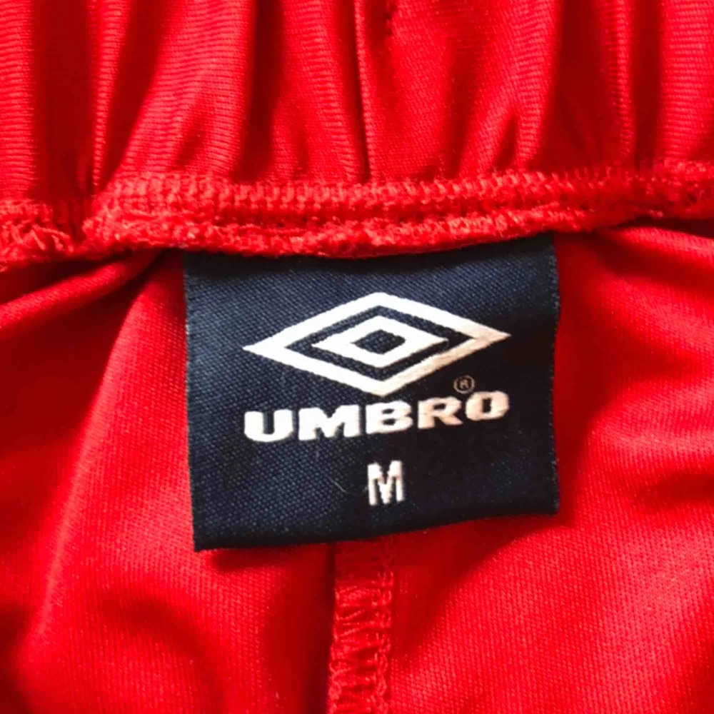 Superskönt röda short i märket Umbro köpta från Urban Outfitters. Kommer aldrig till användning säljer därför. Frakt tillkommer.. Shorts.