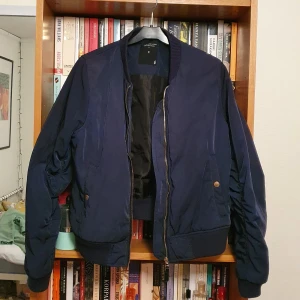 Mörkblå bomberjacka strl M - Mörkblå bomberjacka från Lager 157 i storlek M. Knappt använd. Köparen betalar frakten och betalning sker via swish